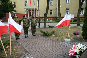 Funkcjonariusze składaja kwiaty pod obeliskiem 