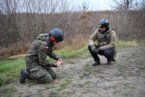 Instruktor wraz ze słuchaczką szkolenia pirotechnicznego podczas zajęć w trerenie 