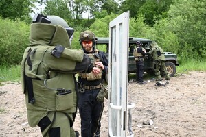 Instruktorzy wraz ze słuchaczami w kombinezonach przeciwwybuchowych 