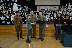 Funkcjonariusze Centrum Szkolenia SG uroczyście wreczają mundury z napisem Straż Graniczna uczniom klas pierwszych 