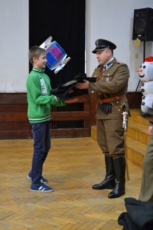 Funkcjonariusze Centrum Szkolenia SG uroczyście wreczają mundury z napisem Straż Graniczna uczniom klas pierwszych 
