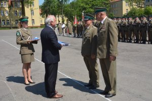 Burmistrz Kętrzyna Pan Krzysztof Hećman przekazuje na ręce Komendanta Centrum Szkolenia Straży Granicznej płk. SG Michała Stachyry flagę naszego miasta 
